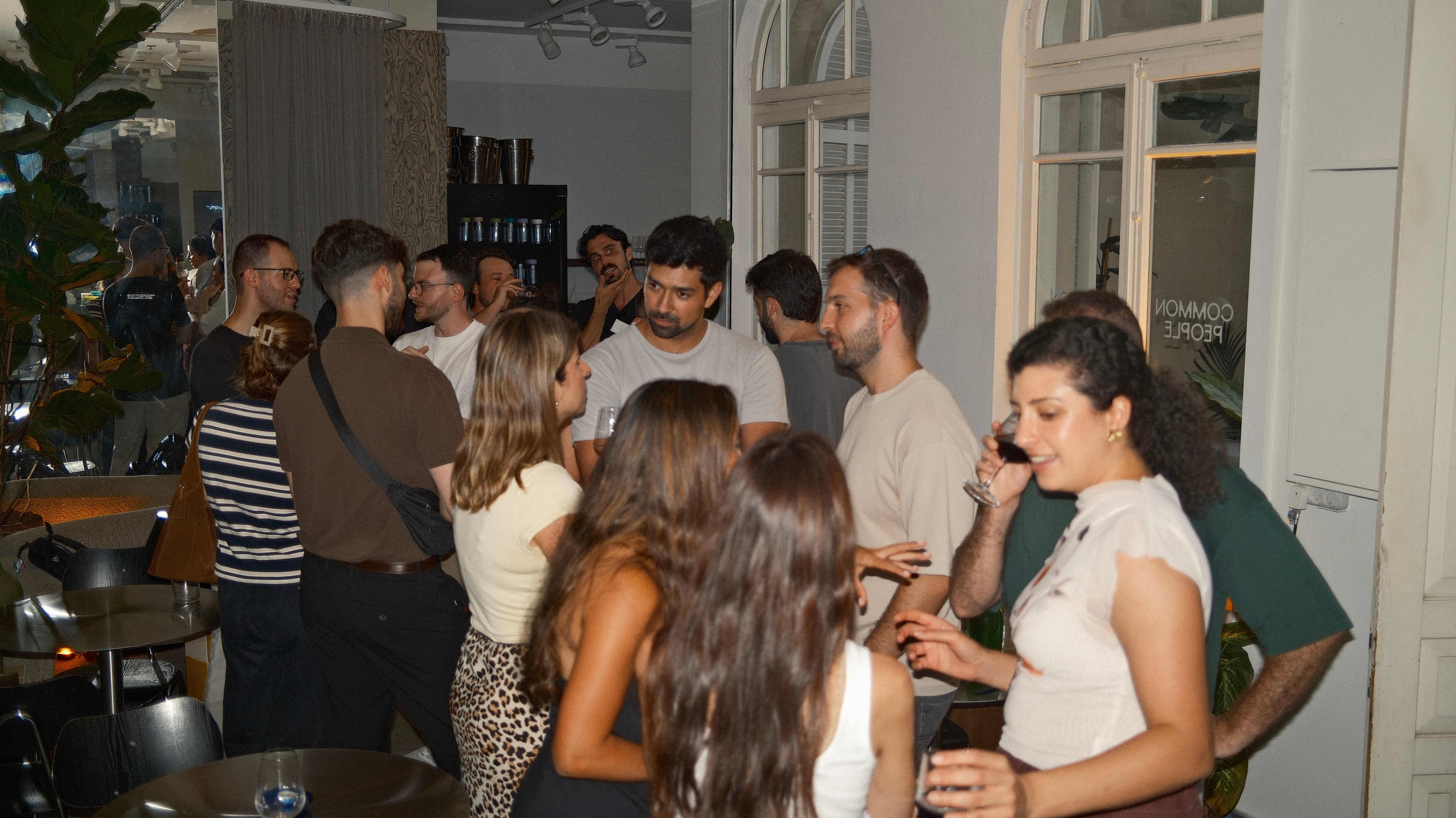 Guests mingling with wine at a 6PM Club evening in Tel Aviv
